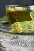 Linden blossoms on a glass cup plate. photo