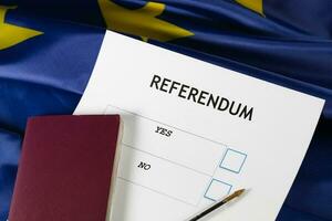 EU Referendum ballot paper, black pen, and passport on the table. photo