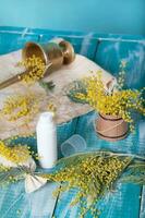 Mimosa cream dispenser on a wooden surface. Closeup photo