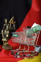 Euros in the shopping cart placed on a German flag. photo