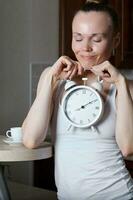 Young caucasian lady is drinking espresso at bar table in the kitchen photo
