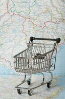 Mini shopping cart on a map. photo