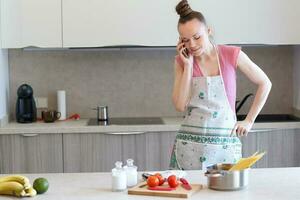 Young housewife in the kitchen photo