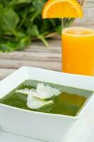 Spinach cream soup and a glass of fresh orange juice photo