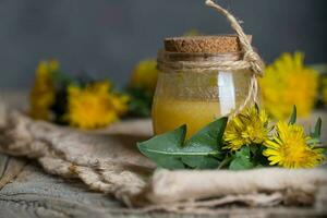 Dandelion  honey in a glass bottle on a piece of sackcloth. photo