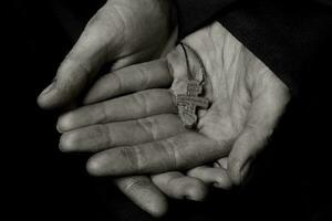 de madera hecho a mano cruzar en el palma de un campesino mujer. foto
