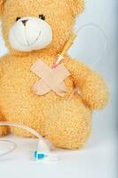 Teddy bear with blood transfusion system. Closeup photo