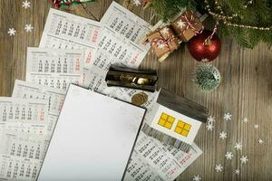 Blank sheet of paper and small paper house with coins on the New Year's background. photo