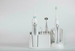 ultrasónico cepillo de dientes equipo en un gris antecedentes. foto