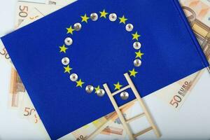 Ladder and pins on an European flag. Closeup photo