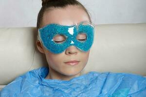 Young lady is keeping eye gel mask. photo
