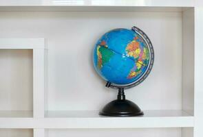 Colorful paper globe on a book shelf. photo