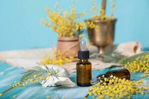 Mimosa essential oil on a wooden surface. photo