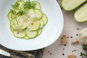 Oven baked zucchinis with parmesan cheese,parsley leaves and fresh garlic photo