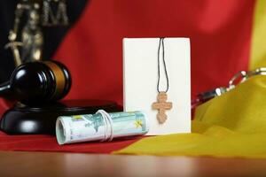 Bible and wooden cross placed close to money. photo