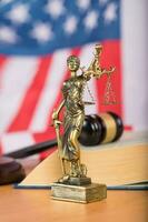 Statue of Themis and judge's gavel on a table. photo