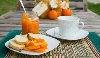 Mandarina mermelada y un taza de calentar Leche foto