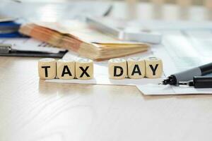 Word Tax Day composed of wooden letters. Closeup photo