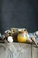 Cotton honey in a glass bottle on a wooden surface. photo