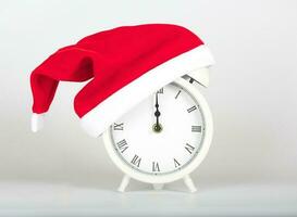 Vintage alarm clock in Santa Claus hat. photo