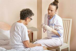 Geriatrician visits a senior woman photo