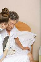 Geriatrician visits a senior woman photo