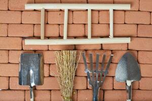 Agricultural tools on a brick wall. Background. photo