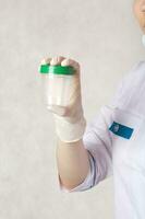 A collection cup for urine test. Closeup photo