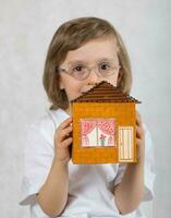 Boy of five years is keeping handmade carton paper house. photo