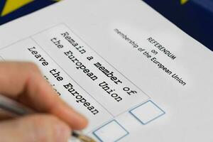 EU Referendum ballot paper, black pen, and passport on the table. photo