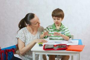 The mother checks the homework of her son photo