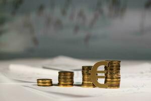 Cutout of euro sign at stacks of coins. photo