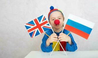 Boy keeps two flags of the UK and Russia. photo