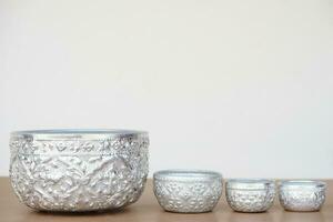 Set of silver bowls, arranges from big to small. Buddhists use bowl to temple or do ceremony, ritual that involves Buddhism and use in Thai Songkran festival  as water bowl. Handicrafts style of Thai. photo