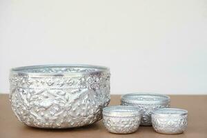 Set of silver bowls, Big and small on table.Buddhists use bowl to temple or do ceremony, ritual that involves Buddhism and use in Thai Songkran festival  as water bowl. Handicrafts style of Thai. photo