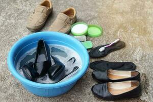 Shoes washing on bowl, use brush, old toothbrush and detergent to clean and scrub. Concept, take care, maintenance footwears from dirt and bad smell for using long time. Hygienic ,sanitary and healthy photo