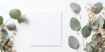 Minimalist Greeting Card Mockup with Delicate Dry Eucalyptus Leaves - Top View on a Clean White Background, photo