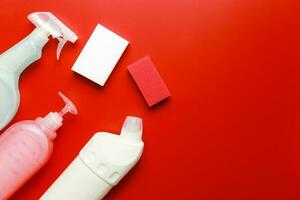 Flat lay cleaning products, Cleaning spray on red background and sponges photo