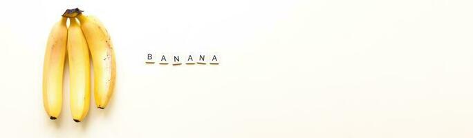 Banner Flatly bananas. The word bananas from wooden letters. Veganism, fruitarianism photo