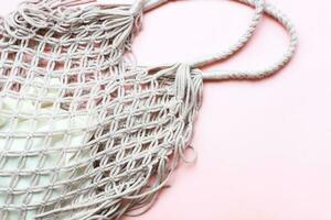 Flat lay mesh bag on pink background. Zero waste. Ecology, rejection of plastic photo