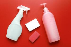 plano laico limpieza productos y esponjas en un rojo antecedentes. limpiar arriba foto