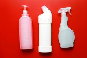 Flat lay cleaning products on a red background. Cleaning bottle mockup photo