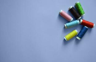 spools of thread on a blue background, a banner for an atelier, tailoring, sewing threads, photos for a textile factory, a place for text