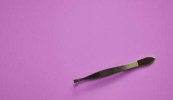 tweezers on a pink background, modeling, decoration and lamination of eyebrows, medical tweezers, a place for text photo