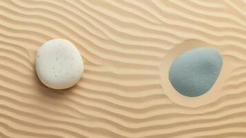 top view of two stones with blue and grey spots on beige sand photo
