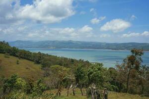 Seascape amidst trees and mountain landscape photo