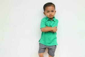 Portrait of a serious little Asian boy who looks unhappy, isolated on the white background photo