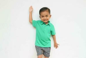 Portrait of a cute little Asian boy raising his hand while smiling and looking at the camera, isolated on the White Background photo