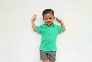 Portrait of a cute little Asian boy raising his hands while smiling and looking at the camera, isolated on the White Background photo