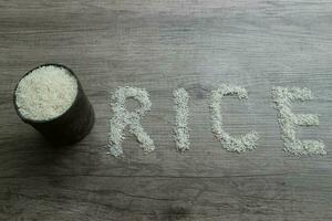 Rice, rice grains form RICE lettering on the wooden background photo